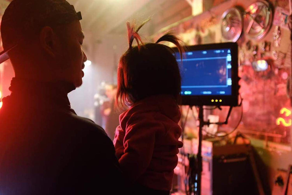 Luis Guanzon holding his daughter behind the scenes of Quincy's "Snuggle Up" Music Video
