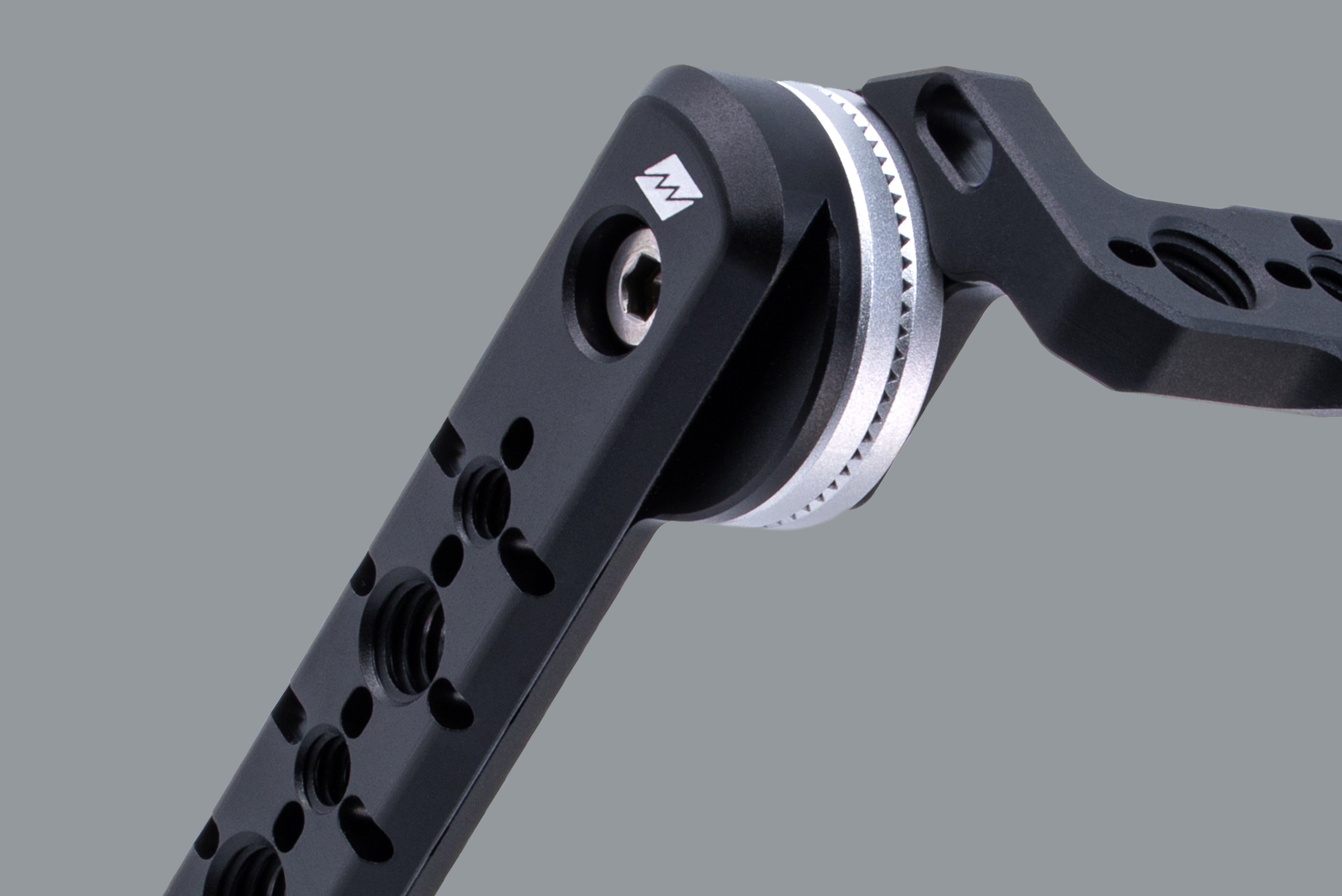 Close-up studio shot of Beastgrip RT Mount, showing integrated NATO rail along with 1/4"-20 and 3/8"-16 threaded mounts and locating pin slots for secure accessory attachment