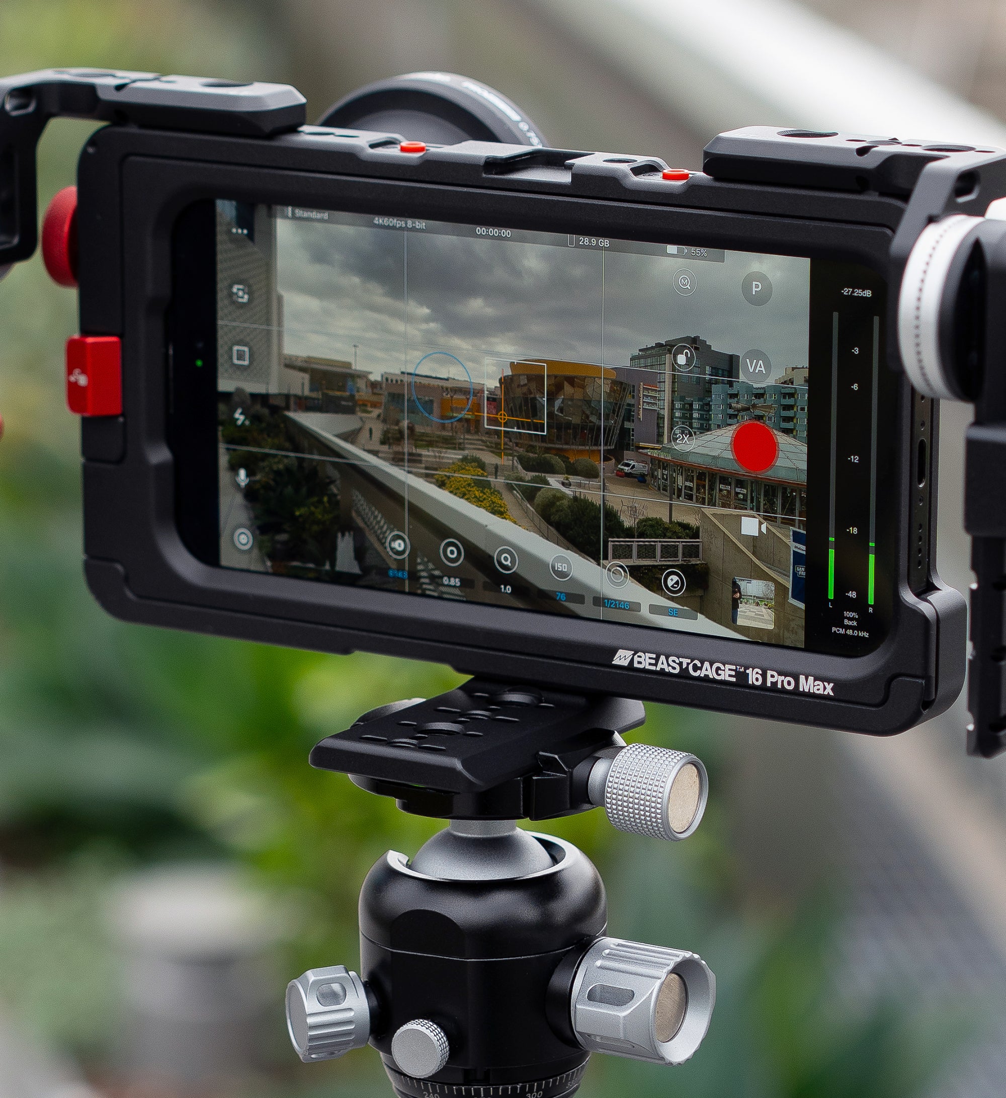 Lifestyle close-up of Beastgrip Quick Release Plate mounted to bottom of Beastcage, rigged with LT and RT Mounts, 0.75X wide-angle lens, and filming outdoors with Beastcam app on tripod — complete mobile rig for wide cinematic shots.