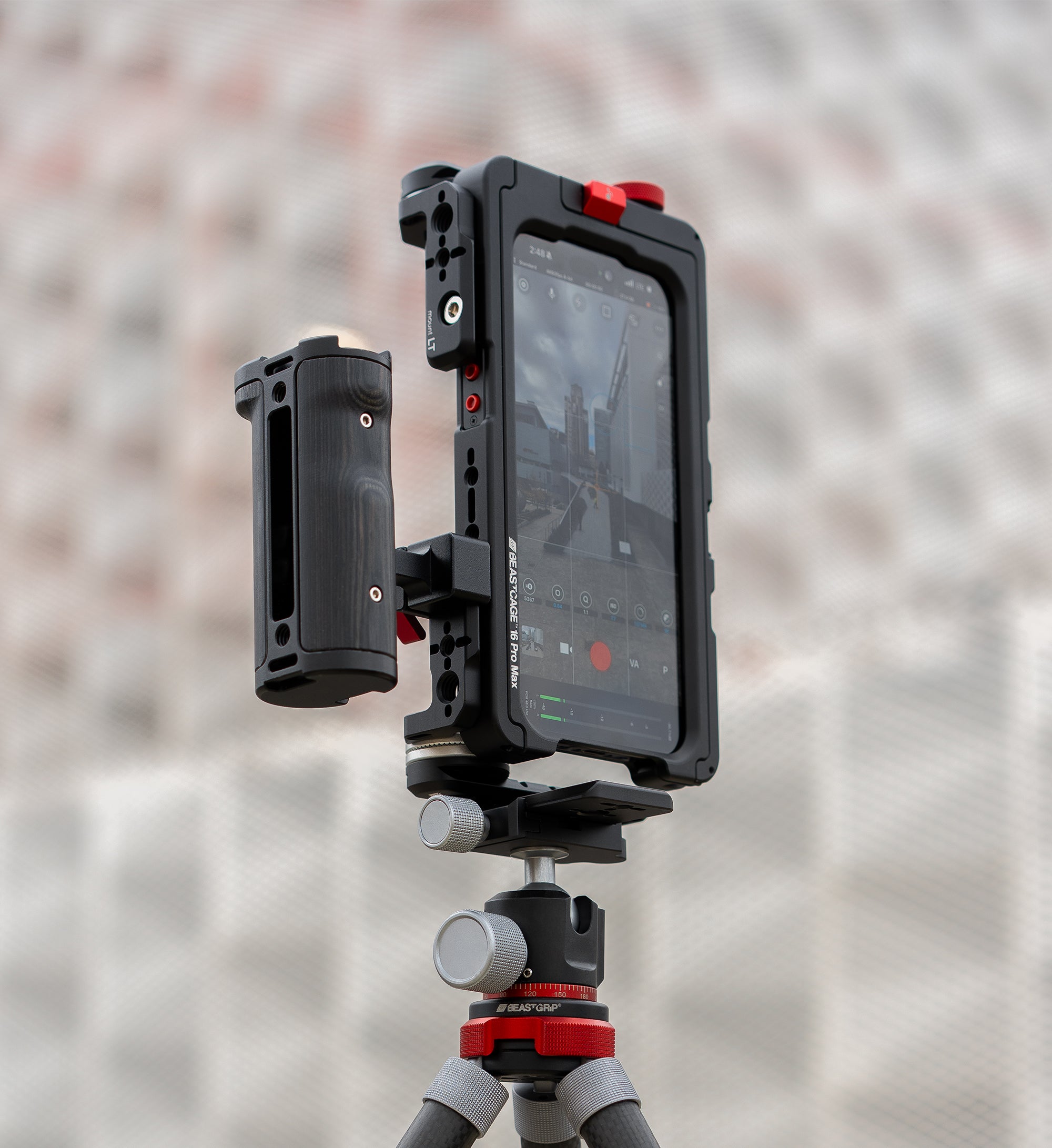 Lifestyle shot of Beastcage rig mounted vertically on tripod via Beastgrip RT Mount, with side handle, 0.75X wide-angle lens, and Beastcam app — vertical iPhone video rig for cinematic mobile content creation.
