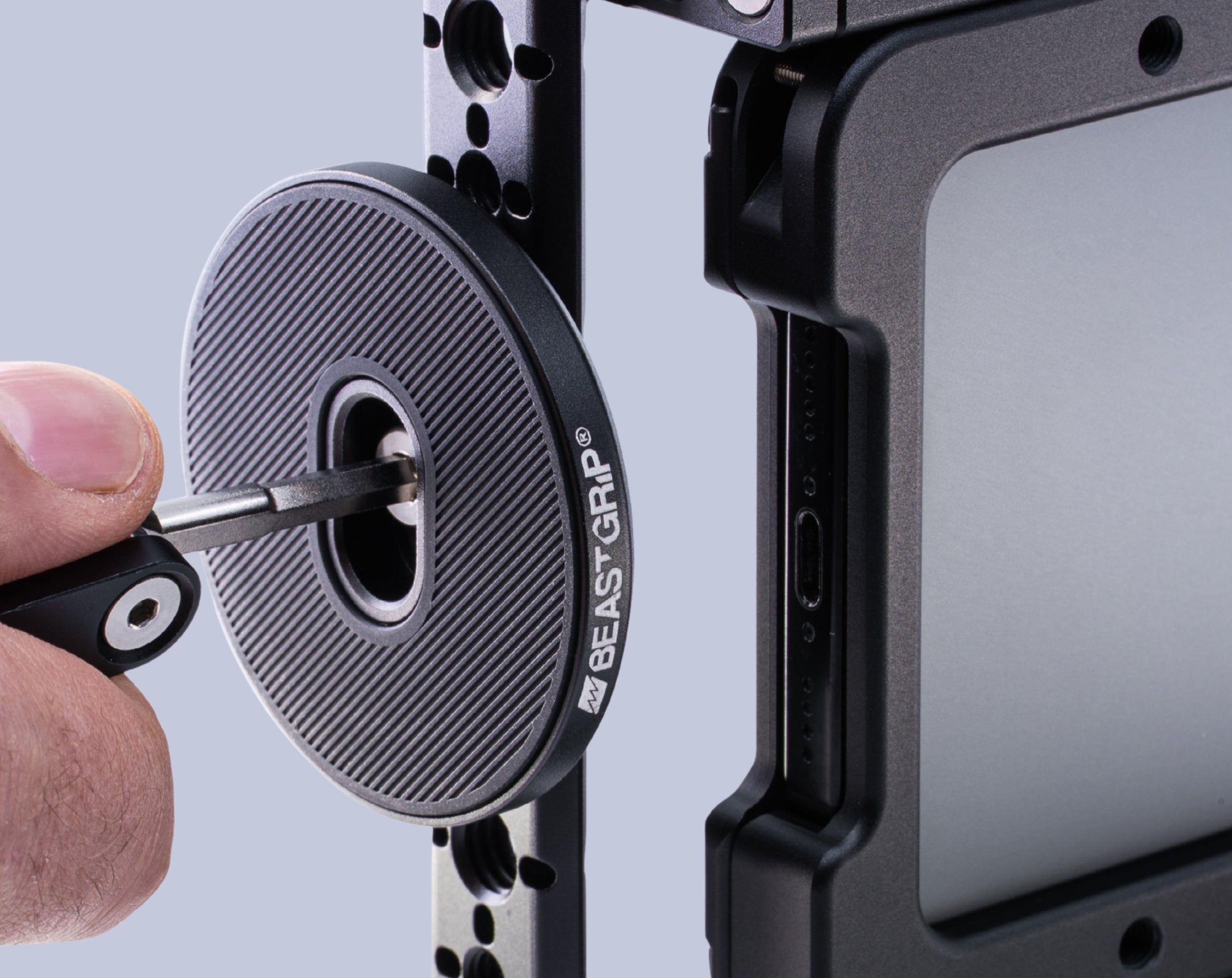 Close-up of Beastgrip Magnetic Mount being attached to an iPhone camera rig with a ¼"-20 screw.