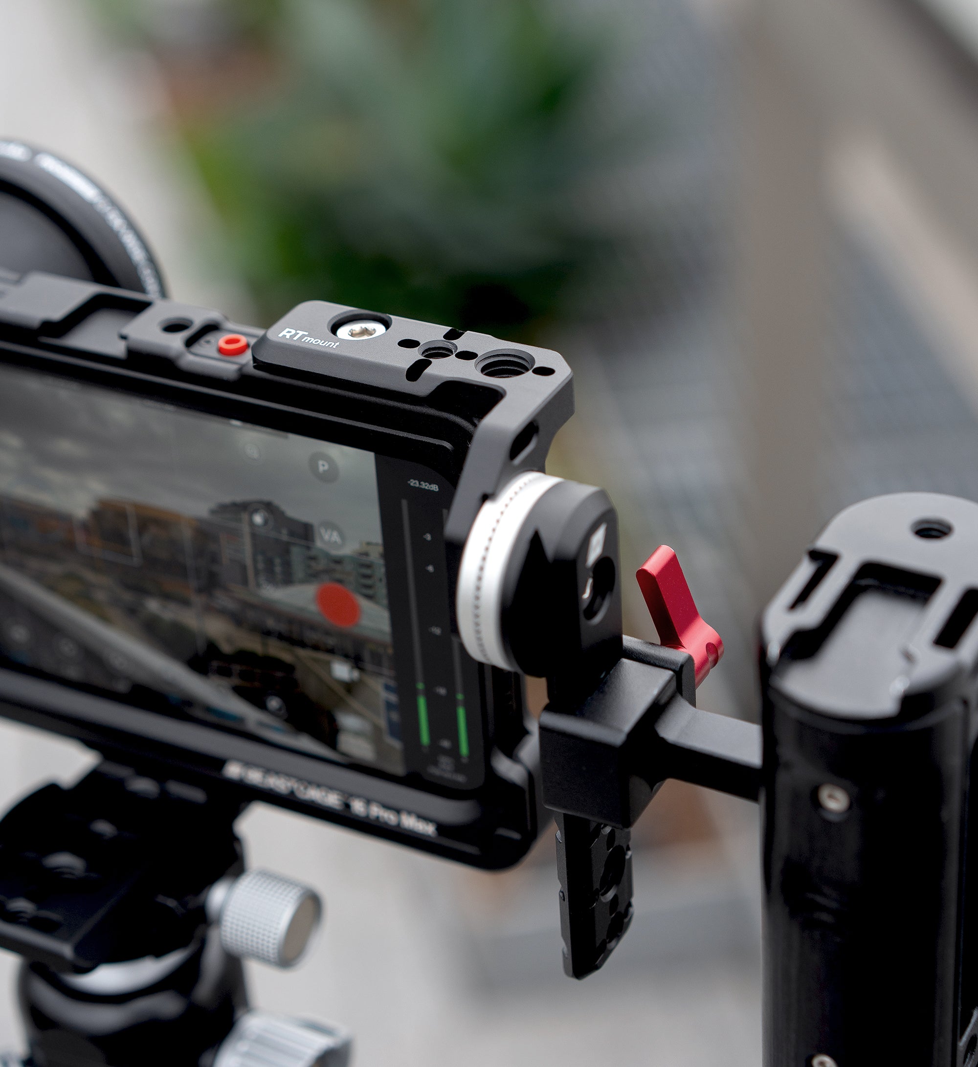 Lifestyle close-up of Beastgrip RT Mount attached to Beastcage for iPhone 16 Pro or 16 Pro Max, mounted on tripod and filming with Beastcam app — professional mobile rig setup for stable video capture.