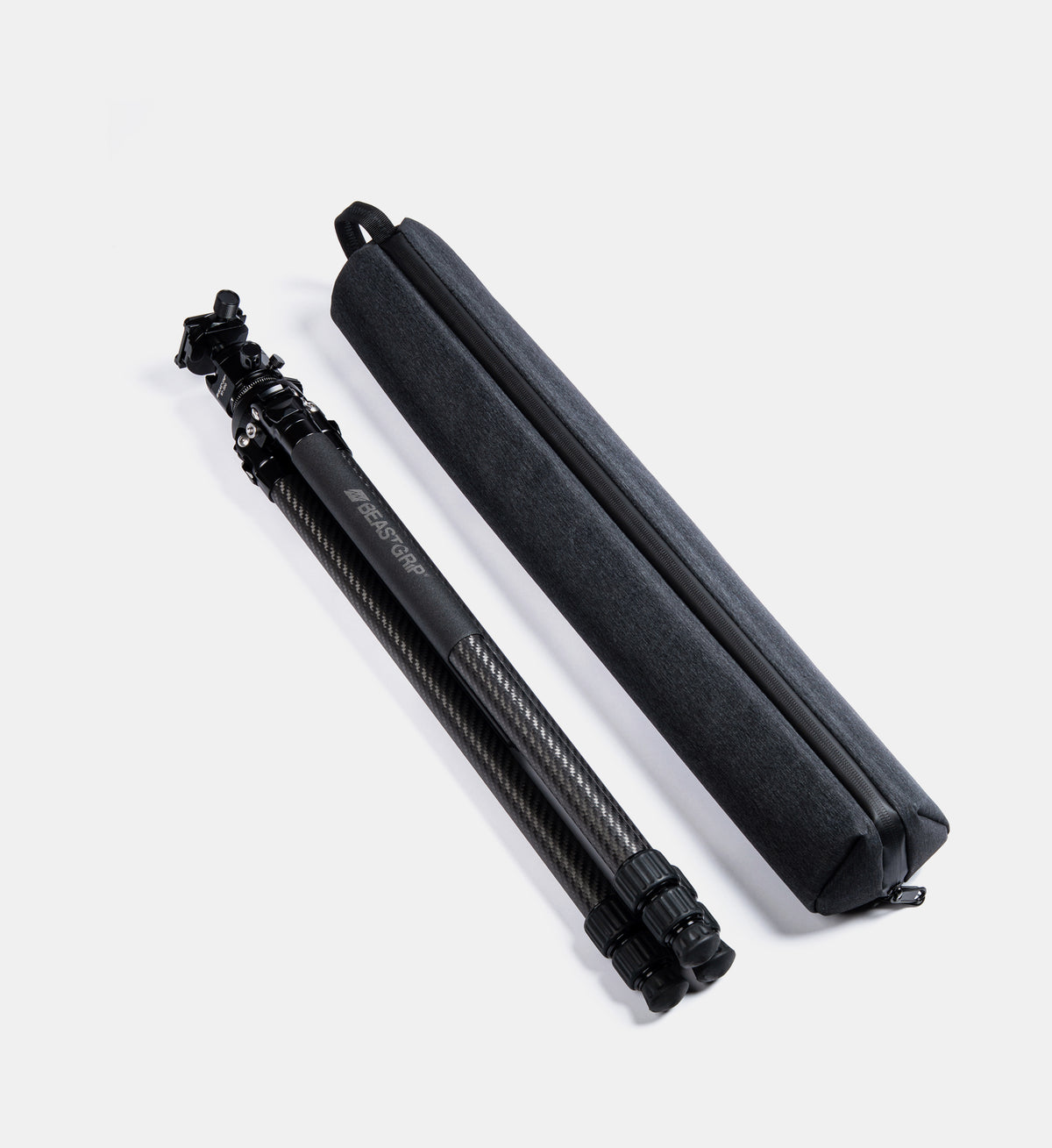 Beastgrip BT-200 carbon fiber tripod in its compact folded position alongside the included carrying bag for easy storage and transportation.