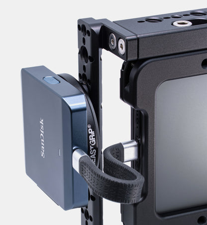 Close-up of Beastgrip Magnetic Mount for MagSafe accessories attached to iPhone cage with ¼"-20 screw, holding a SanDisk CFexpress card reader