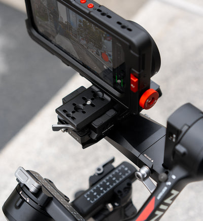 Lifestyle close-up of Beastcage rig mounted to DJI gimbal via Beastgrip Quick Release Plate, featuring Beastgrip lens and recording with Beastcam app — professional mobile video setup for iPhone.
