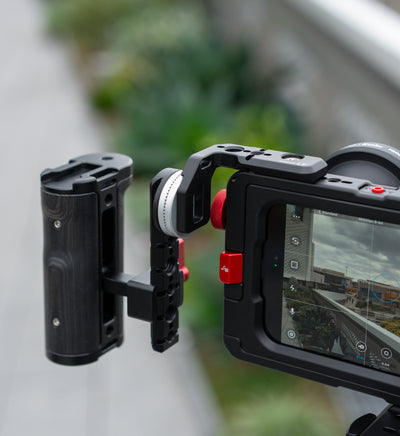 Lifestyle shot of Beastgrip LT Mount with side handle attached to Beastcage 16 Pro Max, paired with 0.75X wide-angle lens — recording with Beastcam app for professional mobile filmmaking.