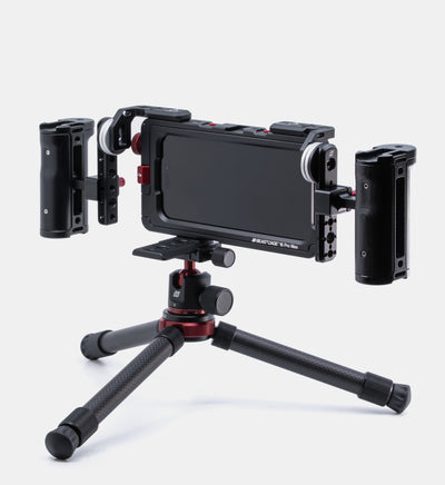 Beastgrip RT and LT Mounts attached to top of Beastcage for iPhone 16 Pro or 16 Pro Max, facing rear with two Beastgrip side handles mounted via NATO rails — full rig secured to Beastgrip BT-60 mini tripod using Beastgrip Quick Release Plate for professional mobile video production.
